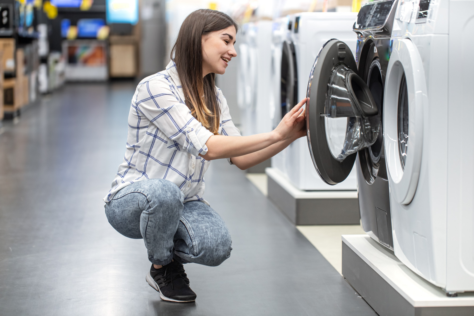 mulher em uma loja escolhendo uma máquina para comprar